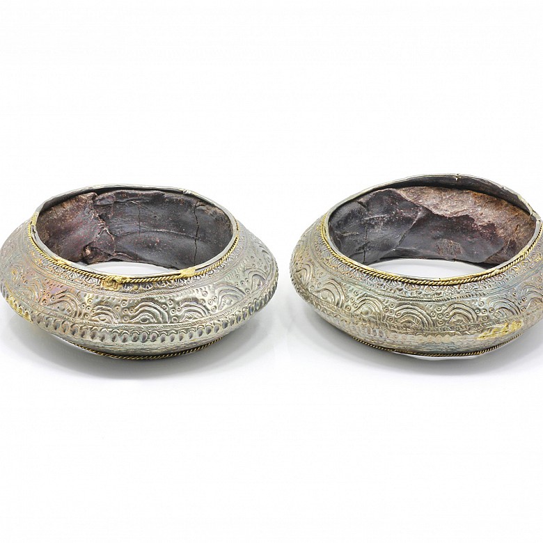 Pair of silver bracelets, ceramic or terracotta interior.