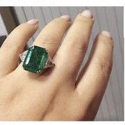 Ring with a large Colombian emerald of 11.19ct and triangle cut diamonds on both sides.