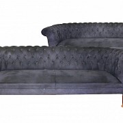 Pareja de sofás chester con tapicería de color azul oscuro.