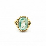 Ring in 18k yellow gold, set in the center with an oval green glass.