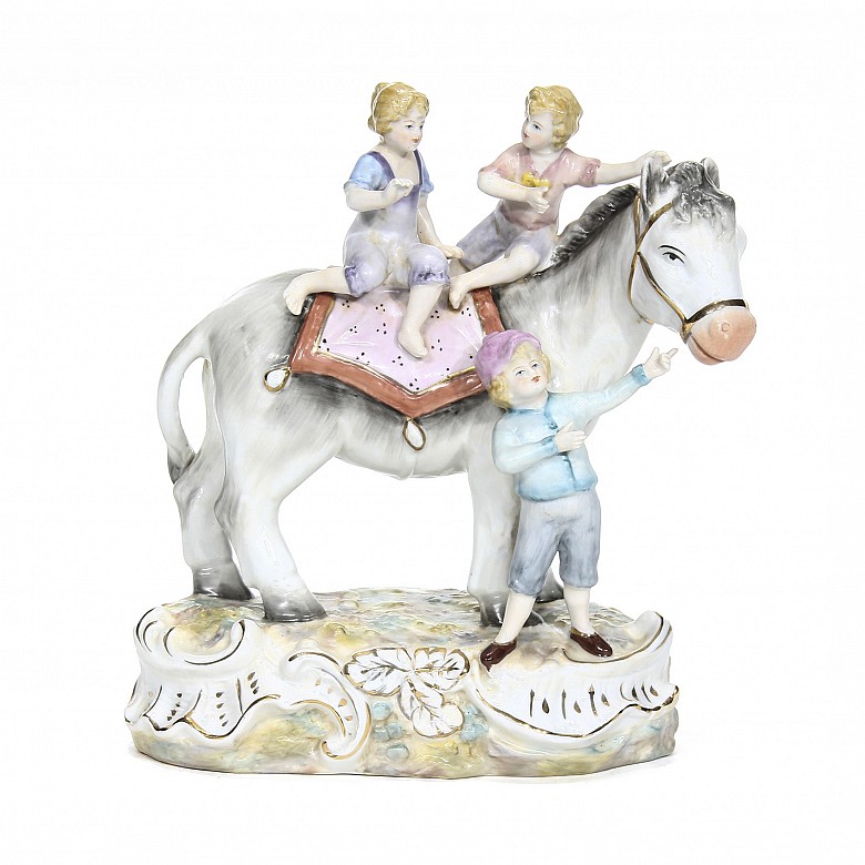 Figura de porcelana alemana “Tres niños jugando con un burro”, s.XX
