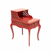 Red lacquered wood side table with oriental decoration and gold accents.