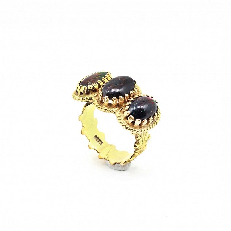 Ring in 18k yellow gold with three red and black fire opal.