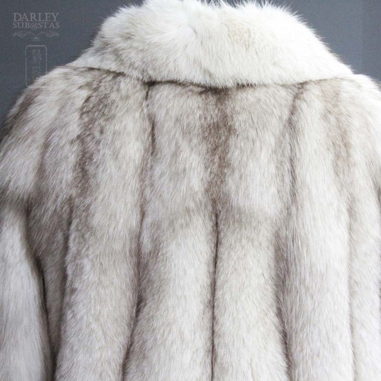 Abrigo de piel de zorro blanco largo.