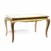 Mesa con patas doradas y tapa de espejo.