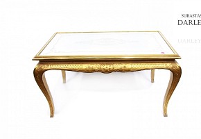 Mesa con patas doradas y tapa de espejo.