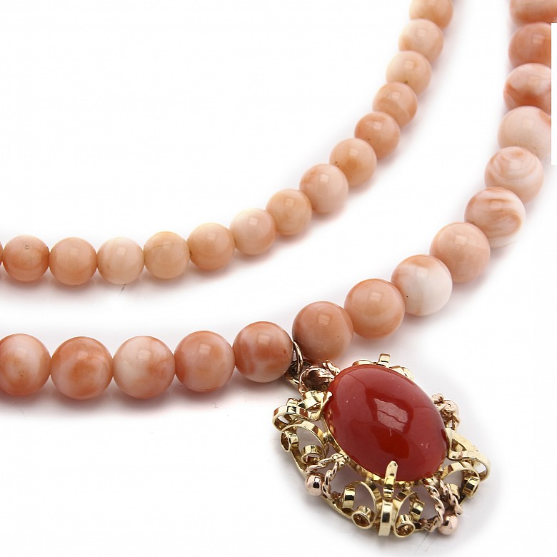 Long coral bead necklace with pendant.