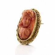 Carved coral cameo brooch, with 18k yellow gold frame.