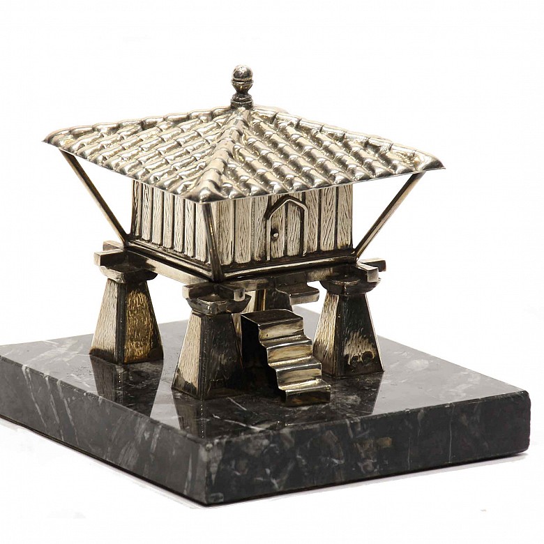Silver sculpture of a raised granary on a black marble base.
