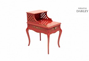 Red lacquered wood side table with oriental decoration and gold accents.