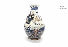 Jarrón de cerámica china en azul y blanco con un dragón en relieve rodeando el cuello, s.XX.