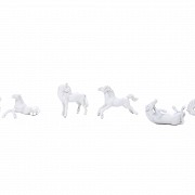 Seven miniature white porcelain horses.
