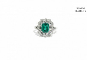 Ring with central Colombian emerald and diamonds.