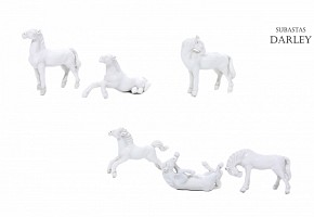 Siete caballos de porcelana blanca en miniatura.
