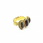 Ring in 18k yellow gold with three red and black fire opal.