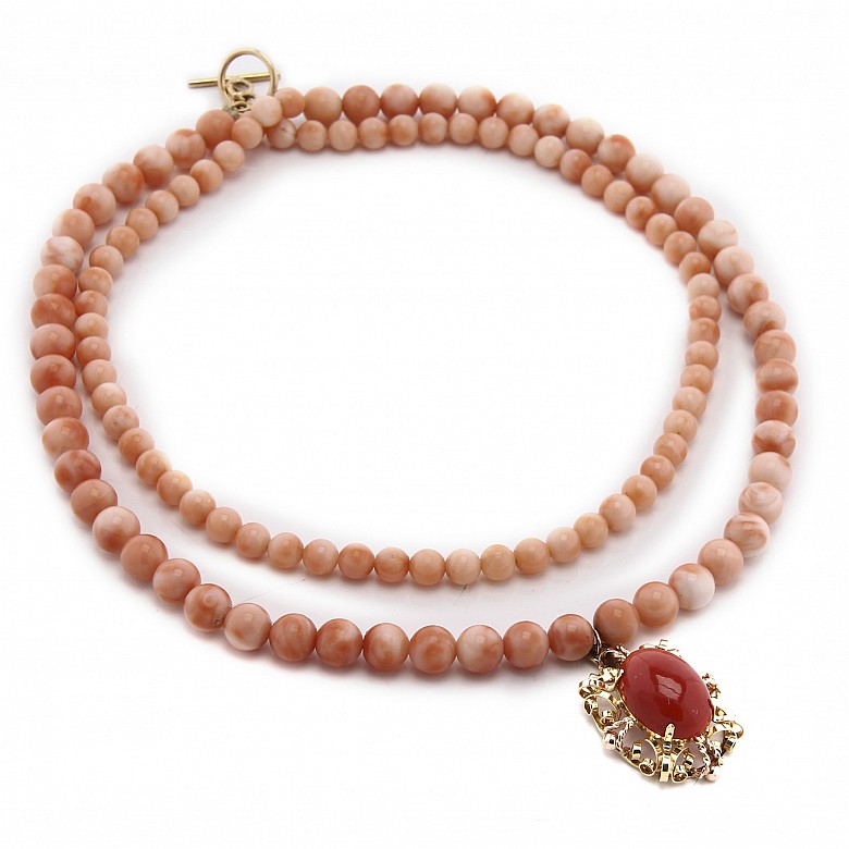 Long coral bead necklace with pendant.