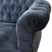 Pareja de sofás chester con tapicería de color azul oscuro.