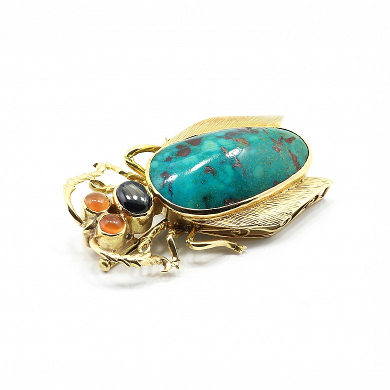 Broche con forma de escarabajo en oro amarillo de 18k, turquesa natural y gemas.