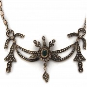 Antique metal choker with diamonds and emeralds.